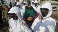 Petugas Satpol PP Kabupaten Bogor menggunakan pakaian hazmat membawa seorang pelanggar PSBB pra Adaptasi Kebiasaan Baru (AKB) dengan tandu menuju pemakaman di kawasan Stadion Pakansari, Kabupaten Bogor, Jawa Barat, Minggu (6/9/2020).