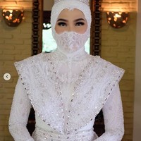 Inge Amalia Nasution dan pria idamannya, Adit, menikah pada akhir pekan kemarin di Plataran Cilandak, Jakarta. Pada hari bahagianya itu, Inge tampil serba putih. Mulai dari gaun pengantin, hijab hingga masker yang dipakainya berwarna putih. Foto: Dok. Instagram @bennusorumba