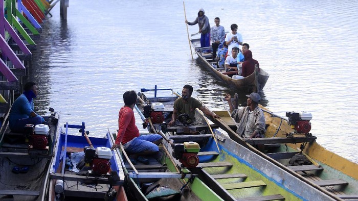 Seorang warga suku bajau menjemur teripang laut di desa Torosiaje.