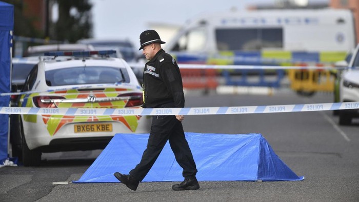 A police officer and vehicles are seen at a cordon in Irving Street in Birmingham after a number of people were stabbed in the city centre, Sunday, Sept. 6, 2020. British police say that multiple people have been injured in a series of stabbings in a busy nightlife area of the central England city of Birmingham.(Jacob King/PA via AP)