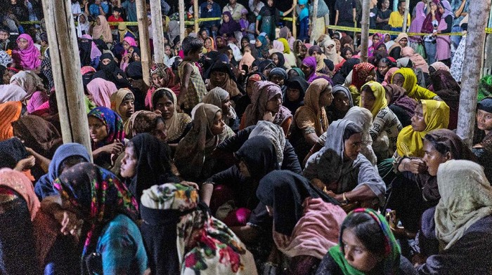 300 Pengungsi Rohingya Belabuh di Aceh An ethnic Rohingya woman is assisted to walk by others after the boat carrying them landed in Lhokseumawe, Aceh province, Indonesia, early Monday, Sept. 7, 2020. Almost 300 Rohingya Muslims were found on a beach in Indonesia's Aceh province Monday and were evacuated by military, police and Red Cross volunteers, authorities said. (AP Photo/Zik Maulana)