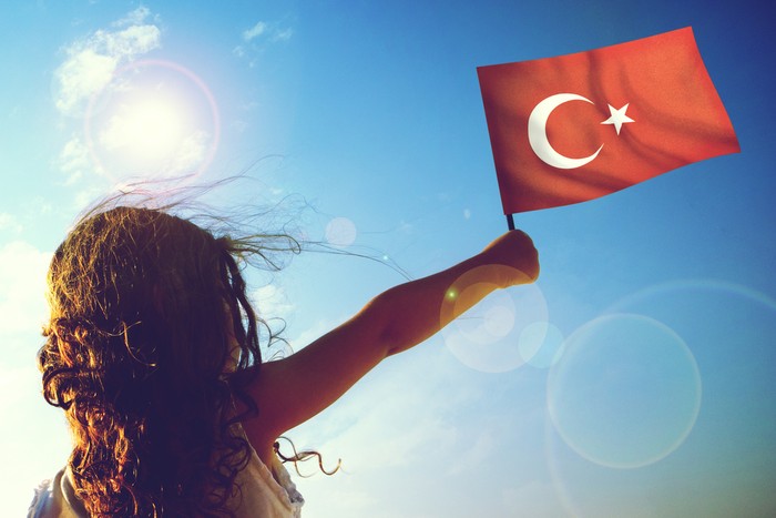 Little girl waving Turkish flag on sunny beautiful day