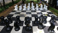 Tampak pion, benteng, kuda, menteri hingga raja berukuran besar tersusun rapi di lapangan catur yang identik dengan warna hitam putih.