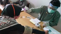 Perawat Ardi memeriksa salah satu pendaki di rute Gunung Putri di desa terakhir Gunung Gede. Pengecekan kesehatan dimulai pukul 06.00 WIB, padahal sejumlah rombongan pendakian start lebih awal.  (Femi Diah/detikTravel)