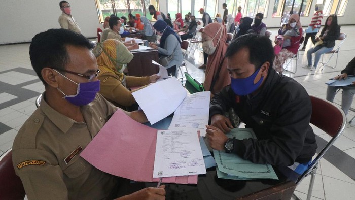 PENDAFTARAN BANTUAN USAHA MIKRO MEMBLUDAK Warga antre dengan menerapkan jaga jarak saat mendaftarkan diri menjadi calon penerima bantuan tunai usaha mikro di gedung serbaguna Bagawanta, Kediri, Jawa Timur, Selasa (8/9/2020). Pendaftaran program realisasi pemulihan ekonomi nasional untuk 12 juta pelaku usaha mikro yang sedianya dilakukan di kantor Dinas Koperasi Kediri terpaksa dipindahkan ke gedung serbaguna Bagawanta guna menanggulangi penyebaran COVID-19 karena membludaknya pendaftar. ANTARA FOTO/Prasetia Fauzani/foc.