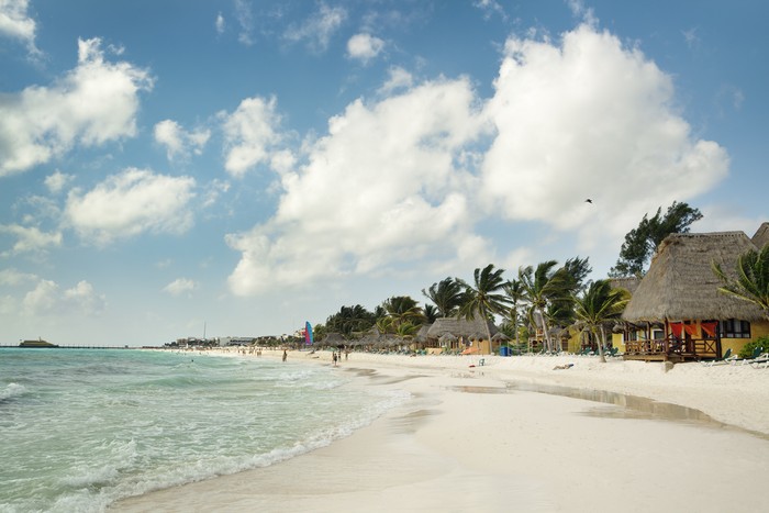 Beach resort hotels and beach chairs along the Caribbean Sea beach of Playa del Carmen, along the Riviera Maya near Cancun, Mexico. An idyllic travel destination for a holiday vacation and winter tropical climate get-away.