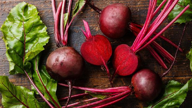 Red Beetroot with herbage green leaves on wooden background