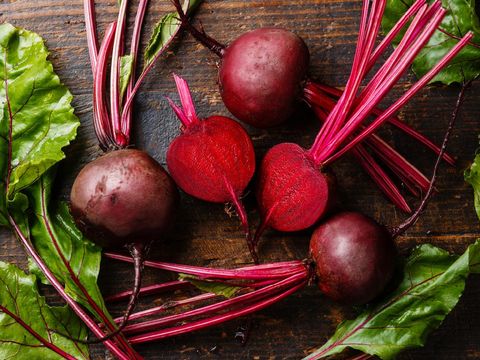 Red Beetroot with herbage green leaves on wooden background