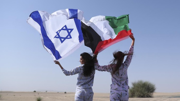 Israeli model May Tager, left, holds Israels blue-and-white flag bearing the Star of David while next to her Anastasia Bandarenka, a Dubai-based model originally from Russia, waves the Emirati flag, during a photo shoot in Dubai, United Arab Emirates, Sunday, Sept. 8, 2020. (AP Photo/Kamran Jebreili)