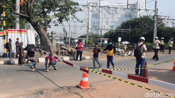 Perlintasan kereta api (KA) di Jalan Perjuangan, Kota Bekasi, ditutup sebagian. Namun warga nekat mengolong di bawah perlintasan.