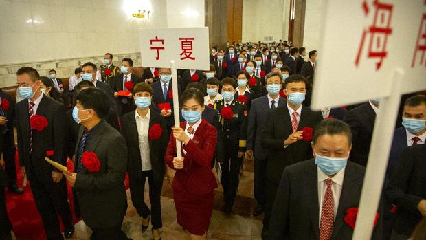 Attendees wearing face masks arrive for an event to honor some of those involved in China's fight against COVID-19 at the Great Hall of the People in Beijing, Tuesday, Sept. 8, 2020. Chinese leader Xi Jinping is praising China's role in battling the global coronavirus pandemic and expressing support for the U.N.'s World Health Organization, in a repudiation of U.S. criticism and a bid to rally domestic support for Communist Party leadership. (AP Photo/Mark Schiefelbein)