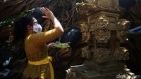 Seorang warga dengan memakai pakaian tradisional khas Bali tengah sembahyang.