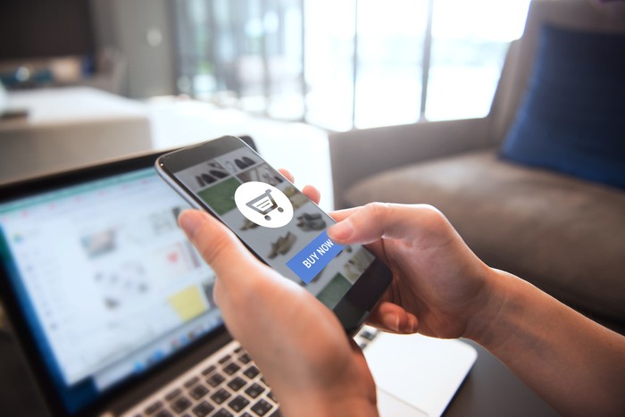 Ilustrasi belanja online Online payment. Hands of woman using mobile smartphone and laptop computer for online shopping.