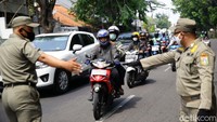 Seorang pengendara dihentikan karena tidak memakai masker.