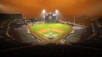 Langit berwarna oranye memayungi Stadion bisbol Oracle Park. AP Photo/Tony Avelar.