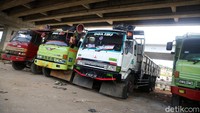 Truk-truk diparkir berjajar di kolong tol tersebut.