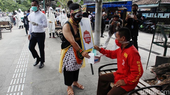 Polda DIY membagikan masker untuk mencegah penyebaran COVID-19 di Jalan Malioboro, Kamis (10/9/2020). Mereka bagi-bagi masker dengan mengenakan kostum wayang seperti semar dan gatotkaca.
