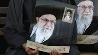 Salah seorang warga juga tampak membawa poster bergambar pemimpin tertinggi Iran, Ayatollah Khomeini saat melakukan aksi protes di Tehran. AP Photo/Vahid Salemi.