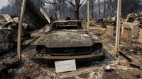 Tiupan angin membuat api cepat merembet ke permukiman warga dan menghanguskan harta benda, seperti mobil. AP Photo/Paula Bronstein.
