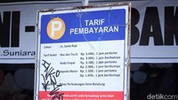 Plang parkir kotor oleh coretan tangan jahil.