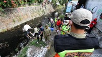 Petugas tampak mengawasi para pelanggar masker saat sedang membersihkan anak Sungai Pepe di Kebalen, Surakarta, Jawa Tengah.