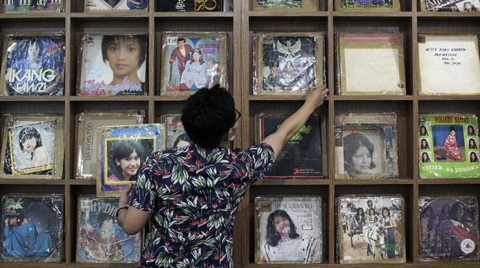 Pegawai RRI Surabaya menunjukkan piringan hitam album lagu lawas di Ruang Restorasi Piringan Hitam di RRI Surabaya, Jawa Timur, Jumat (11/9/2020). Lembaga Penyiaran Publik (LPP) Radio Republik Indonesia (RRI) Surabaya yang memiliki sekitar 8.000  piringan hitam album lagu dari masa ke masa tersebut telah melakukan restorasi atau merekam ulang menjadi digital sebanyak 3.000 piringan hitam album lagu sedangkan selebihnya rusak termakan usia. ANTARA FOTO/Didik Suhartono/foc.