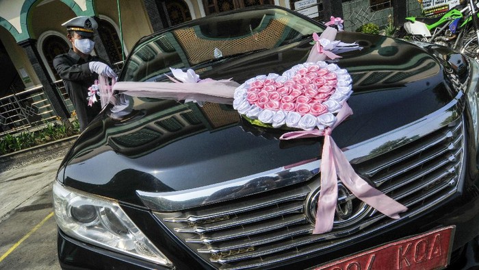 Pengantin menggunakan mobil dinas Pemerintah Kota Bekasi untuk menuju lokasi pernikahan di Bekasi, Jawa Barat, Sabtu (12/9/2020). Wakil Walikota Bekasi menyediakan fasilitas gratis mobil dinas pada hari Sabtu dan Minggu untuk antar jemput warga yang akan melaksanakan pernikahan saat pandemi COVID-19. ANTARA FOTO/ Fakhri Hermansyah/hp.