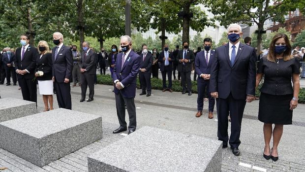 From left, New York Gov. Andrew Cuomo, Jill Biden with her husband Democratic presidential candidate and former Vice President Joe Biden, former NYC Mayor Mike Bloomberg, Vice President Mike Pence and his wife Karen, observe a moment of silence on Friday, Sept. 11, 2020, in New York.  The names of nearly 3,000 victims of the Sept. 11, 2001 terror attacks will be read by family members.  (AP Photo/Mary Altaffer)
