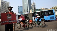 Sejumlah poster berisi imbauan untuk mematuhi protokol  kesehatan pencegahan virus Corona dibawa petugas saat melakukan sosialisasi di kawasan Bundaran HI, Jakarta.  