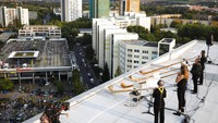 Sejumlah musisi memainkan alat musik alphorn, alat musik yang memiliki bentuk seperti terompet, saat menggelar konsek di atas atap sebuah apartemen yang berada di kawasan Dresden, Jerman, Sabtu (12/9) waktu setempat. 