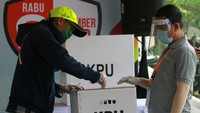 Petugas Kelompok Penyelenggara Pemungutan Suara (KPPS) bertugas dengan menggunakan alat pelindung diri (APD) lengkap guna menekan laju penyebaran virus Corona. ANTARA FOTO/Muhammad Iqbal