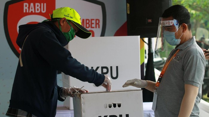 Petugas Kelompok Penyelenggara Pemungutan Suara (KPPS) dengan menggunakan alat pelindung diri (APD) mengawasi pemilih di bilik suara khusus saat simulasi pemungutan suara dengan protokol kesehatan pencegahan dan pengendalian COVID-19 di TPS 18 Cilenggang, Serpong, Tangerang Selatan, Banten, Sabtu (12/9/2020). KPU akan menyiapkan satu bilik suara khusus di setiap TPS yang diperuntukan bagi pemilih yang suhu tubuhnya diatas 37 derajat saat pemungutan suara Pilkada serentak 2020. ANTARA FOTO/Muhammad Iqbal/pras.