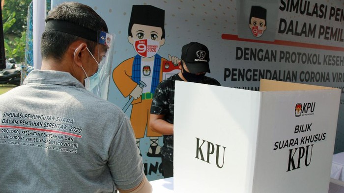 Petugas Kelompok Penyelenggara Pemungutan Suara (KPPS) dengan menggunakan alat pelindung diri (APD) mengawasi pemilih di bilik suara khusus saat simulasi pemungutan suara dengan protokol kesehatan pencegahan dan pengendalian COVID-19 di TPS 18 Cilenggang, Serpong, Tangerang Selatan, Banten, Sabtu (12/9/2020). KPU akan menyiapkan satu bilik suara khusus di setiap TPS yang diperuntukan bagi pemilih yang suhu tubuhnya diatas 37 derajat saat pemungutan suara Pilkada serentak 2020. ANTARA FOTO/Muhammad Iqbal/pras.