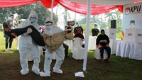 Petugas Kelompok Penyelenggara Pemungutan Suara (KPPS) dengan menggunakan alat pelindung diri (APD) lengkap mengevakuasi pemilih yang pingsan saat akan melakukan pencoblosan ketika Simulasi Pemungutan Suara dengan Protokol Kesehatan Pencegahan dan Pengendalian COVID-19 pada Pilkada Serentak 2020, di TPS 18 Cilenggang, Serpong, Tangerang Selatan, Banten. ANTARA FOTO/Muhammad Iqbal