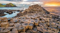 Giants Causeway berada di sepanjang pantai laut di tepi dataran tinggi Antrim di Irlandia Utara. Situs itu terdiri dari sekitar 40.000 kolom basal hitam besar yang mencuat dari laut.