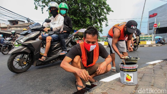 Razia masker masih terus dilakukan di kawasan Ibu Kota. Warga yang melanggar akan dikenakan sanksi beragam, mulai menyapu jalan hingga mengecat pembatas jalan.
