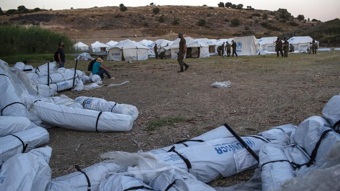 A man pray inside a make shift tent near the burned Moria camp on island of Lesbos, Greece, Sunday Sept. 13, 2020. Greek authorities have been scrambling to find a way to house more than 12,000 people left in need of emergency shelter on the island after the fires deliberately set on Tuesday and Wednesday night gutted the Moria refugee camp. (AP Photo/Petros Giannakouris)