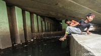 Mereka membawa alat pancing, meski kali ini terlihat kotor mereka meyakini ada ikan di dalamnya.