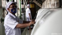 Dua orang pekerja tampak mengenakan masker saat beraktivitas di dalam pabrik.