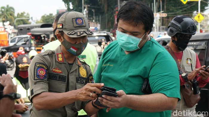 Seorang dokter protes saat terciduk tidak memakai masker ketika berkendara. Ia berdalih, aturan sanksi untuk pengendara tak bermasker tidak disosialisasikan secara maksimal.