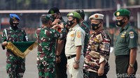 Panglima Kodam Jaya Mayjen TNI Dudung Abdurachman memasangkan lencana penegakan disiplin penerapan protokol kesehatan kepada anggota ormas saat apel pasukan di JIExpo Kemayoran.