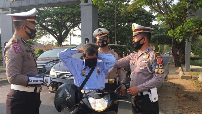 Petugas membagikan masker kepada pengendara.