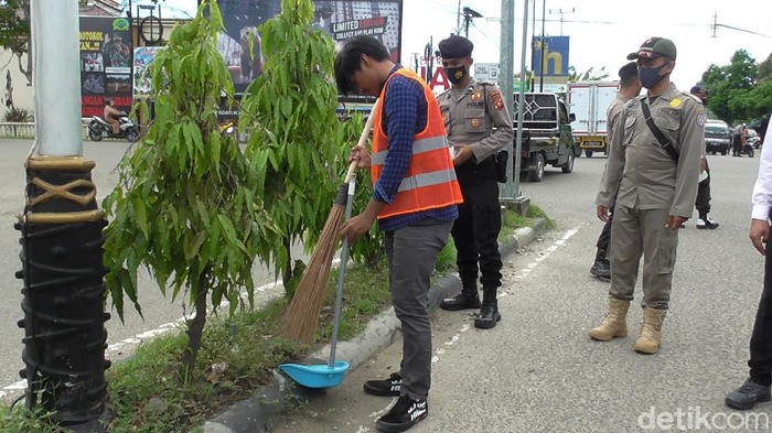 Warga tak bermasker di Gorontalo dihukum menyapu jalan.