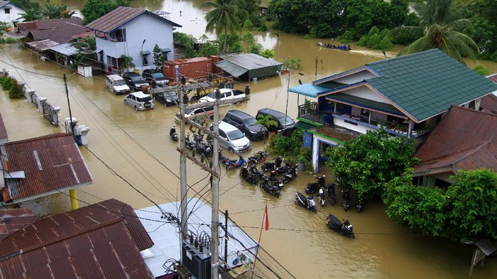 Seorang anak menjemur baju di atap rumahnya yang tergenang banjir di Jalan Ngurah Rai, Putussibau, Kabupaten Kapuas Hulu, Kalimantan Barat, Selasa (15/9/2020). Kota Putussibau masih terendam banjir dan mengalami pemadaman listrik serta jaringan telekomunikasi sejak Minggu (13/9/2020). ANTARA FOTO/Jessica Helena Wuysang/foc.