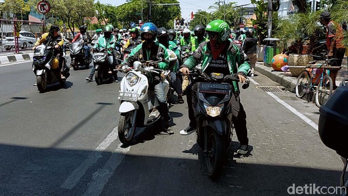 Driver Ojol Rusak Pagar Kantor Grab di Surabaya Ribuan driver Ojol dari berbagai komunitas di Jawa Timur gelar demo menolak pemotongan hasil orderan 20 persen oleh aplikator. Mereka merusak pagar kantor Grab.