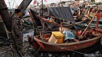 Petugas memantau penerapan protokol kesehatan saat warga beraktivitas di kawasan permukiman kampung nelayan, Cilincing, Jakarta.