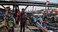 Seorang warga dikenai sanksi saat kedapatan tak menggunakan masker saat beraktivitas di luar rumah di kawasan permukiman nelayan, Cilincing, Jakarta, Selasa (15/9/2020).