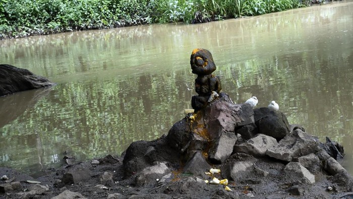 Women sit at the gate of Shrines of the Osun River at the Oshogbo Sacred Grove, the last sacred  forest in southwest Nigeria, on June 3, 2020. - The dense forest Osun-Oshogbo Sacred Grove is believed to host the ethnic Yoruba goddess of fertility, spirit of Osun, other deities associated with water, purity, and artworks, places of worship, in addition to natural herbal pharmacy containing hundreds different species of plants. (Photo by PIUS UTOMI EKPEI / AFP)