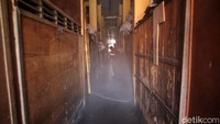 Petugas pemadam kebakaran menyusuri lorong pasar untuk menyemprotkan disinfektan.