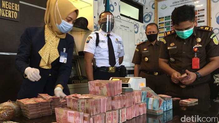 Petugas menghitung uang tersangka korupsi